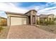 Well-manicured lawn and brick driveway leading up to a home with a two-car garage at 13314 W Dale Ln, Peoria, AZ 85383