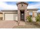 Charming home exterior featuring a brick entryway, two-car garage, and well-maintained landscaping at 13314 W Dale Ln, Peoria, AZ 85383