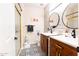 Stylish bathroom with double vanity, modern fixtures, glass shower, and patterned tile flooring at 13350 W La Reata Ave, Goodyear, AZ 85395