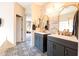 A luxurious bathroom features a double sink vanity, decorative mirrors, and tiled floors at 13350 W La Reata Ave, Goodyear, AZ 85395