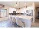 Modern kitchen featuring a large island with seating, quartz countertops, stainless steel appliances and ample white cabinetry at 13350 W La Reata Ave, Goodyear, AZ 85395