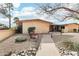 Charming tan house with a cozy bench in the front yard, surrounded by rocks and manicured bushes at 13354 W Stonebrook Dr, Sun City West, AZ 85375