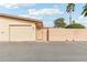 Beige single-car garage and peach courtyard wall, accented by blue sky at 13354 W Stonebrook Dr, Sun City West, AZ 85375