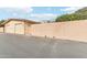 Two beige single-car garages and peach courtyard wall, accented by blue sky at 13354 W Stonebrook Dr, Sun City West, AZ 85375