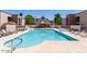 Community swimming pool surrounded by lounge chairs and well maintained landscaping on a sunny day at 1340 N Recker Rd # 254, Mesa, AZ 85205