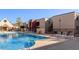 Community pool area with lounge chairs for relaxing and well-maintained landscaping on a sunny day at 1340 N Recker Rd # 254, Mesa, AZ 85205