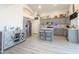 Open kitchen with gray cabinets, stainless steel appliances, a center island, and light wood flooring at 1357 N Balboa Dr, Gilbert, AZ 85234