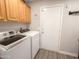 Laundry room with wooden cabinets, washer and dryer units, and a utility door at 1357 N Balboa Dr, Gilbert, AZ 85234