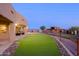 Expansive backyard with artificial turf, a view of the entertainment barn, and convenient access to the main house at 13935 E Smokehouse Trl, Scottsdale, AZ 85262