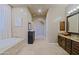 Bright bathroom featuring a soaking tub, black dresser, archway entrance and dual vanities at 13935 E Smokehouse Trl, Scottsdale, AZ 85262