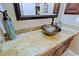 Close up of a granite countertop, bowl sink and decorative pieces in an elegantly styled bathroom at 13935 E Smokehouse Trl, Scottsdale, AZ 85262