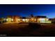 Exterior front view of a custom home at night with sculpture, desert landscaping, and a circular driveway at 13935 E Smokehouse Trl, Scottsdale, AZ 85262