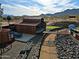 Aerial view of the desert landscaped backyard featuring putting green, outdoor dining, and metal art sculpture at 13935 E Smokehouse Trl, Scottsdale, AZ 85262