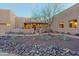 Home's front entrance with desert landscaping, custom gate, and lighted walkway at 13935 E Smokehouse Trl, Scottsdale, AZ 85262