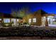 Home's front entrance at night, featuring lit desert landscaping, custom gate, and walkway at 13935 E Smokehouse Trl, Scottsdale, AZ 85262