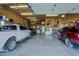 Well-organized garage with multiple vehicles parked inside and ample storage space on shelves at 13935 E Smokehouse Trl, Scottsdale, AZ 85262