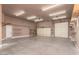 Spacious three car garage with automatic doors, shelving, and neutral colored walls at 13935 E Smokehouse Trl, Scottsdale, AZ 85262