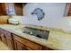 Close-up of cooktop with granite countertops and custom cabinets in a well-appointed kitchen at 13935 E Smokehouse Trl, Scottsdale, AZ 85262