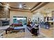 Open-concept living room with a stone fireplace, beamed ceilings, and leather sofas at 13935 E Smokehouse Trl, Scottsdale, AZ 85262