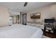 Bedroom features neutral walls, ceiling fan, dresser with TV, and an ensuite bathroom at 1755 W Lawrence Ln, Phoenix, AZ 85021