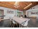 Dining area featuring a modern table, wood ceiling, and views of the surrounding landscape at 1755 W Lawrence Ln, Phoenix, AZ 85021