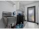 Functional laundry room with stainless steel sink, modern washer and dryer, and storage cabinets at 1755 W Lawrence Ln, Phoenix, AZ 85021