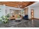 Inviting living room featuring a vaulted wood ceiling, slate flooring, and stylish furniture at 1755 W Lawrence Ln, Phoenix, AZ 85021