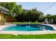 Sparkling blue swimming pool surrounded by lush greenery and well-manicured lawn in a private backyard at 1755 W Lawrence Ln, Phoenix, AZ 85021