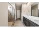 The bathroom features a glass enclosed shower, large mirror and stone counters at 17842 W Getty Dr, Goodyear, AZ 85338