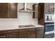 Stylish kitchen featuring a stainless steel range hood and built-in microwave at 17842 W Getty Dr, Goodyear, AZ 85338