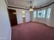 Large bedroom with a ceiling fan, shuttered windows, rose colored carpet, and a walk-in closet at 2025 S Val Vista Dr, Gilbert, AZ 85295