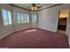 Spacious bedroom features a ceiling fan, shuttered windows, rose-colored carpeting, and access to an ensuite bathroom at 2025 S Val Vista Dr, Gilbert, AZ 85295