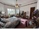 Bedroom features a bed with floral bedding, a ceiling fan, shuttered windows, and antique furnishings at 2025 S Val Vista Dr, Gilbert, AZ 85295