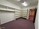 Spacious walk-in closet features built-in shelving and storage solutions with neutral carpeting at 2025 S Val Vista Dr, Gilbert, AZ 85295