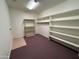 Spacious walk-in closet features built-in shelving and storage solutions with neutral carpeting at 2025 S Val Vista Dr, Gilbert, AZ 85295