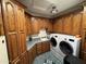 Laundry room with wood cabinetry, a utility sink, and modern washer and dryer at 2025 S Val Vista Dr, Gilbert, AZ 85295