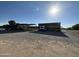 Wide shot of the RV and tractors parked under shelter in an open-air gravel lot on a sunny day at 2025 S Val Vista Dr, Gilbert, AZ 85295