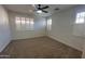 This bedroom features neutral carpet, a ceiling fan, and multiple shuttered windows for natural light at 20840 E Vía Del Palo --, Queen Creek, AZ 85142