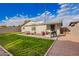 This backyard features a grassy lawn, patio seating area, and a grill, perfect for outdoor entertaining at 2301 E Alpine E Ave, Mesa, AZ 85204