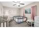 Neutral-toned Bedroom showcasing a crib, play area, and glider chair by a window at 2301 E Alpine E Ave, Mesa, AZ 85204