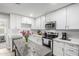 Well-appointed kitchen featuring white cabinetry, modern appliances, and a decorative flower centerpiece at 2301 E Alpine E Ave, Mesa, AZ 85204