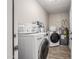 Well-equipped laundry room with a washer, dryer, and storage, complete with wood-look floors at 2301 E Alpine E Ave, Mesa, AZ 85204