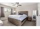 Serene main bedroom featuring a wooden platform bed, soft carpet, and natural light from window at 2301 E Alpine E Ave, Mesa, AZ 85204