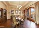 Elegant dining room featuring a wooden table, chandelier, and scenic outdoor views through an arched doorway at 2430 S Geronimo Head Trl, Gold Canyon, AZ 85118