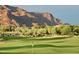 Scenic view of a lush golf course with Superstition Mountain in background at 2430 S Geronimo Head Trl, Gold Canyon, AZ 85118