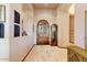 Elegant hallway featuring travertine floors, a decorative wooden door, and a classic grandfather clock at 2430 S Geronimo Head Trl, Gold Canyon, AZ 85118