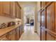 Hallway features ample storage with custom cabinets and countertops, leading to the open living spaces at 2430 S Geronimo Head Trl, Gold Canyon, AZ 85118