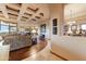 Inviting living room with coffered ceiling, wood floors, and an open layout connecting to the kitchen and dining area at 2430 S Geronimo Head Trl, Gold Canyon, AZ 85118