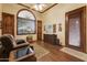 Cozy living room with wood floors, arched window, ceiling fan, and comfortable seating at 2430 S Geronimo Head Trl, Gold Canyon, AZ 85118