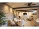 Bright sitting area with stone walls, a ceiling fan, and comfortable chairs at 2430 S Geronimo Head Trl, Gold Canyon, AZ 85118